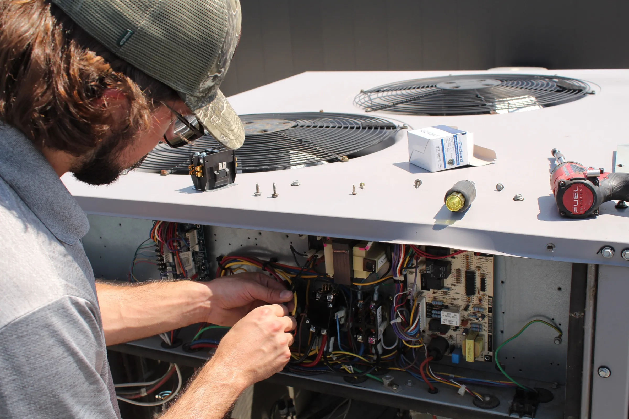 Tiger technician servicing a rooftop HVAC unit